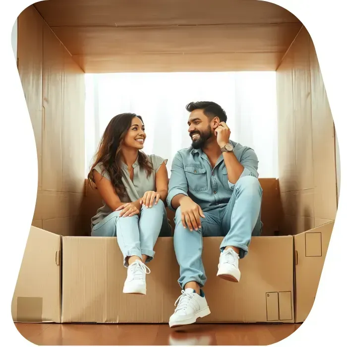 Two guys sitting on the floor of their apartment with Muval moving boxes